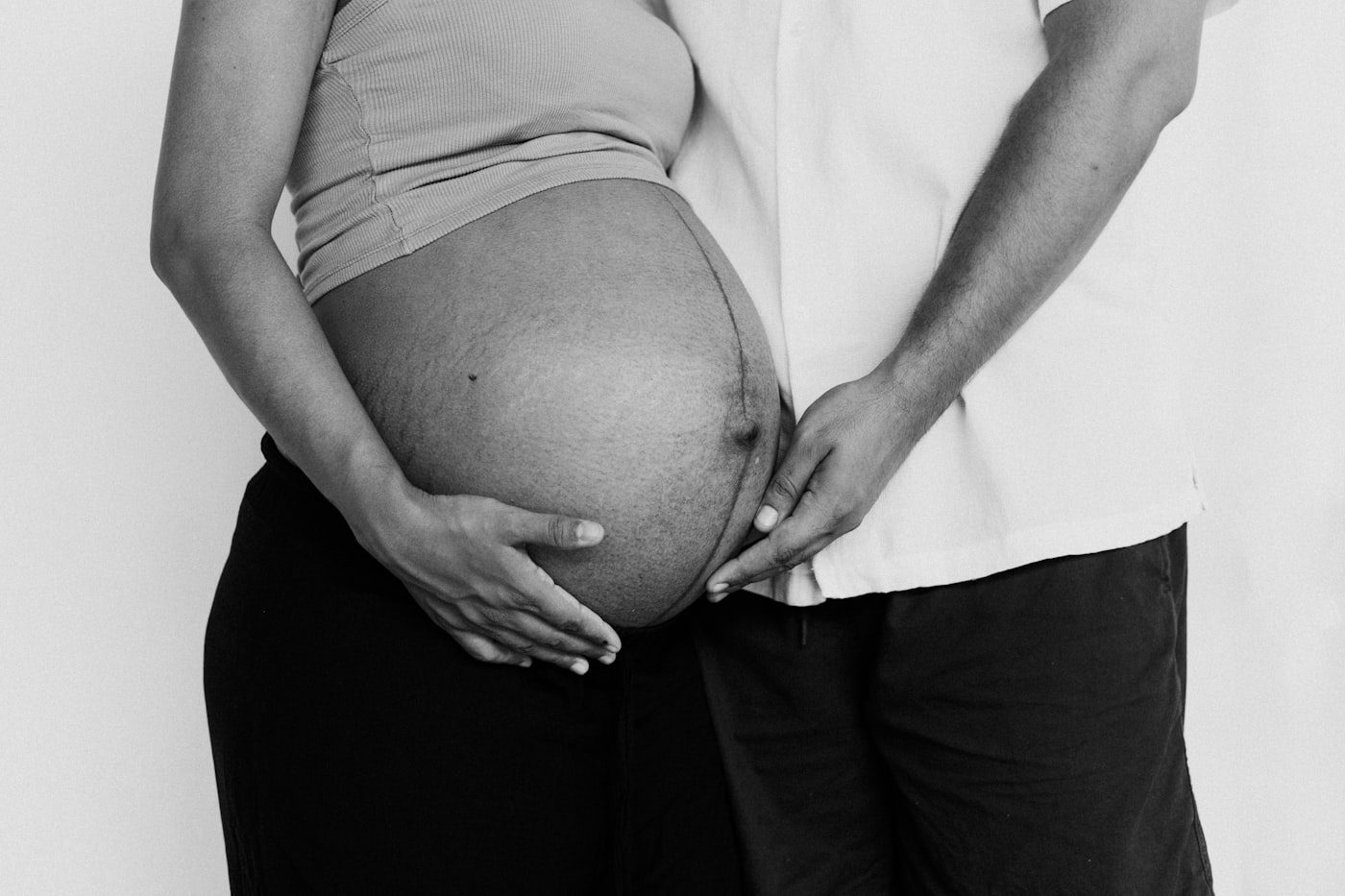 Expectant couple holding their pregnant belly together, illustrating the joyful outcome of preconception care, fertility planning, and IVF support at Femmenest, Delhi NCR